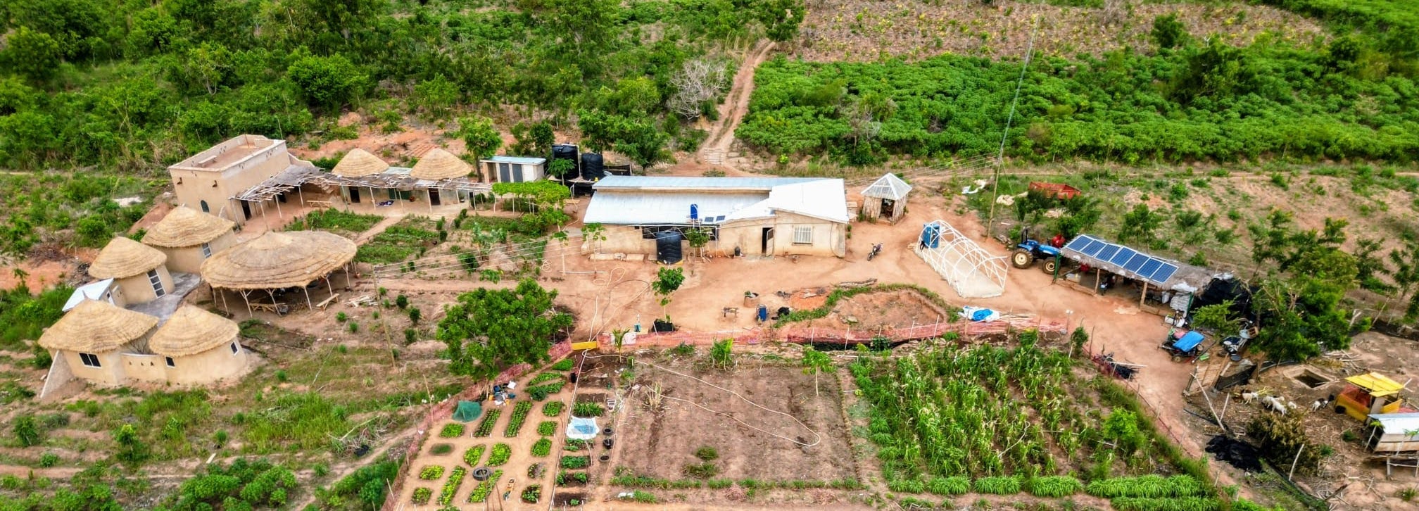 Aerial view of Dream Village beside the Oti River at sunset